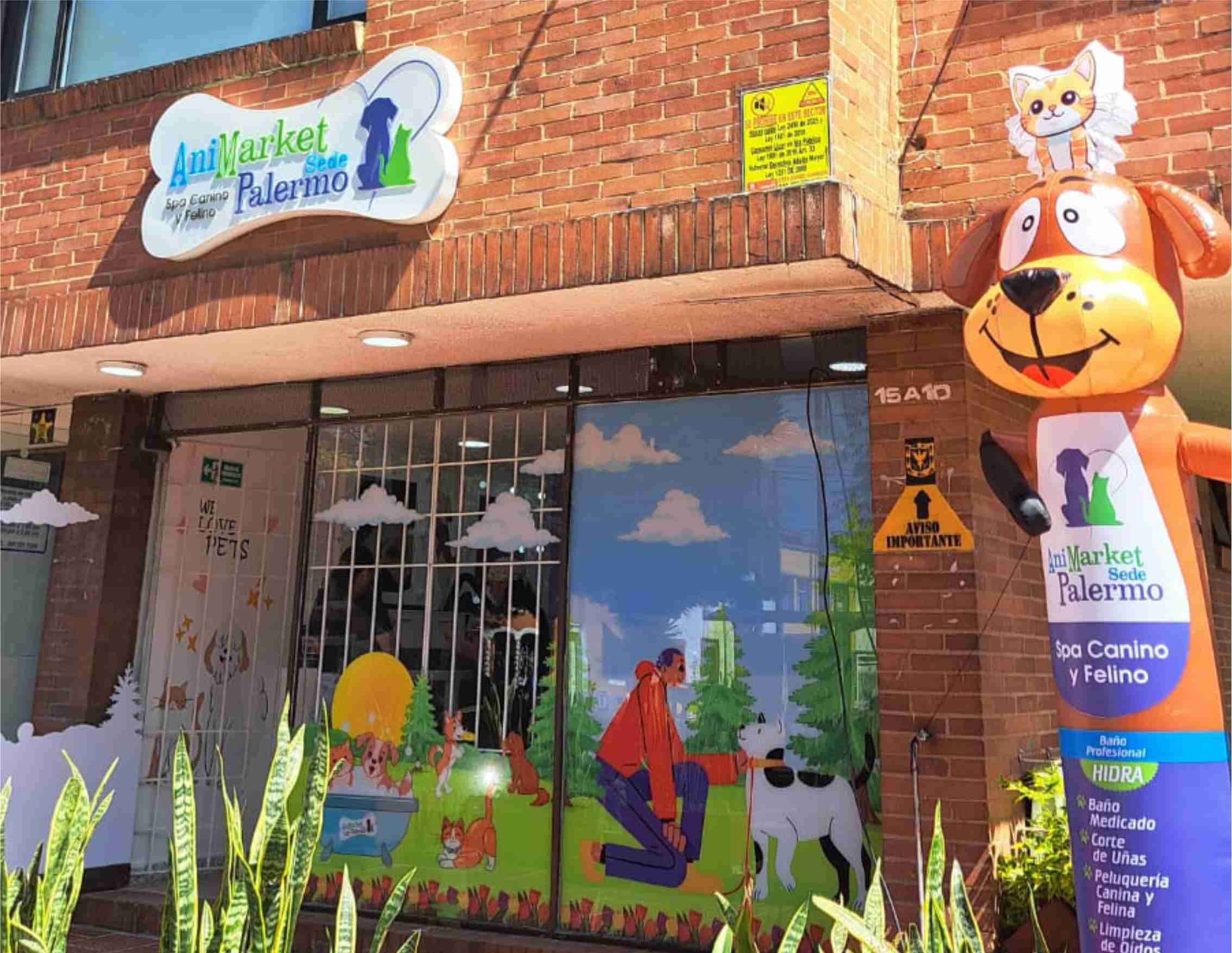 Fachada de AniMarket Sede Palermo con letrero de hueso, murales coloridos y un perro inflable.
